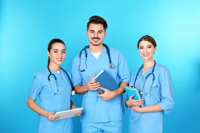 Group of young medical students on color background