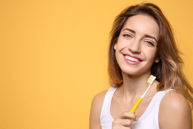 Photo of Portrait of young woman with toothbrush on color background. Space for text