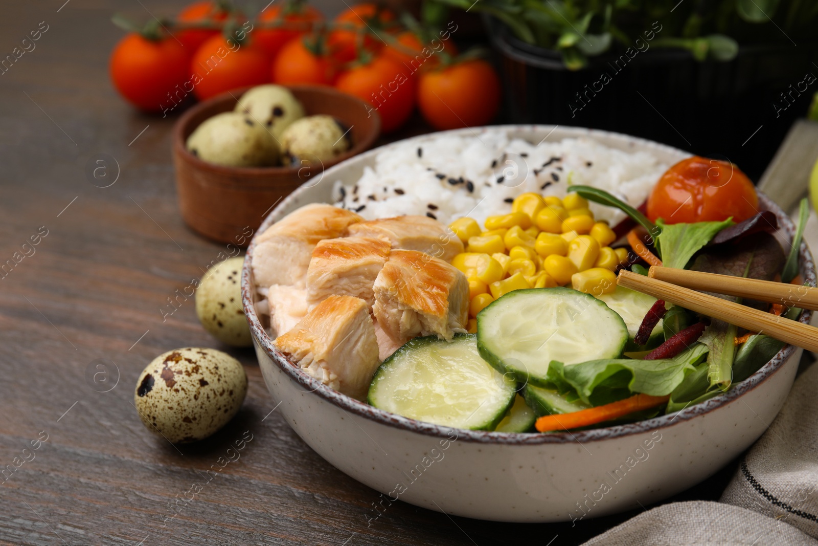 Photo of Delicious poke bowl with meat, rice, vegetables and greens on wooden table, closeup