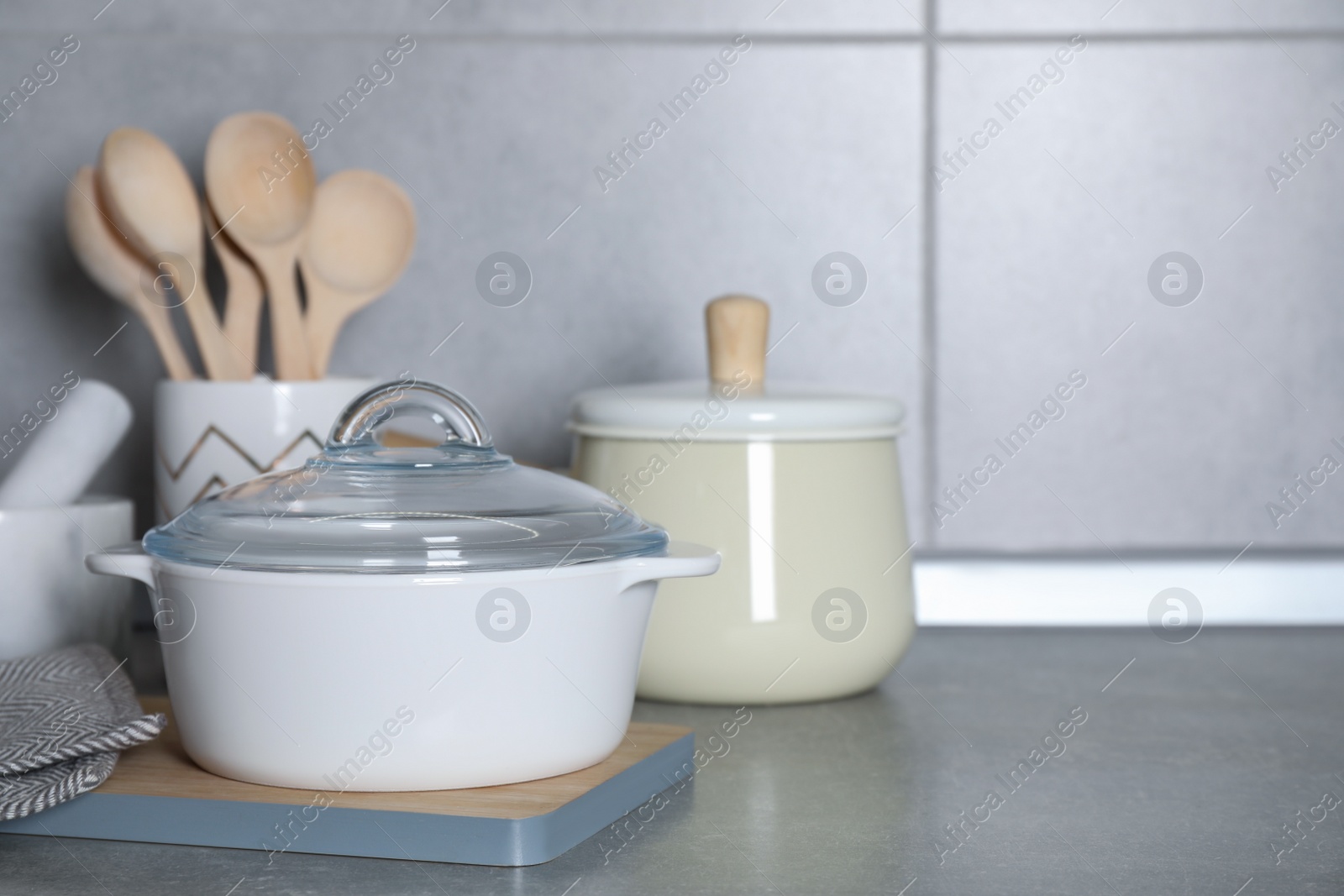 Photo of Cooking utensils and other kitchenware on grey countertop. Space for text