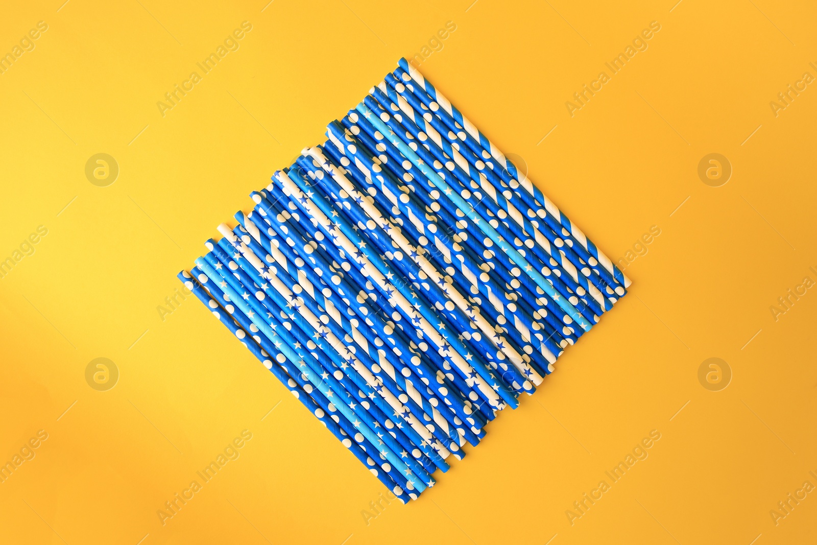 Photo of Many paper drinking straws on yellow background, flat lay