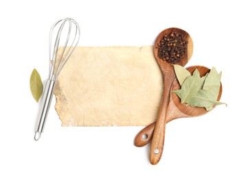 Photo of Old cookbook page, spices and kitchen utensils on white background, top view. Space for text