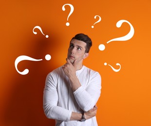 Image of Choice in profession or other areas of life, concept. Making decision, thoughtful young man surrounded by drawn question marks on orange background
