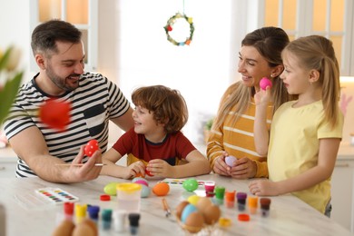 Photo of Happy Easter. Cute family with painted eggs at white marble table in kitchen