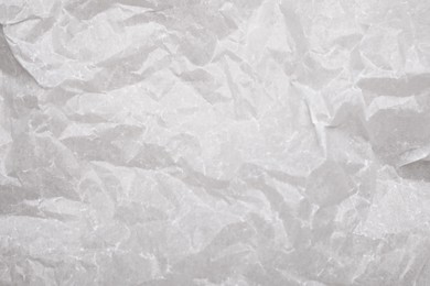 Photo of Texture of crumpled baking paper as background, top view