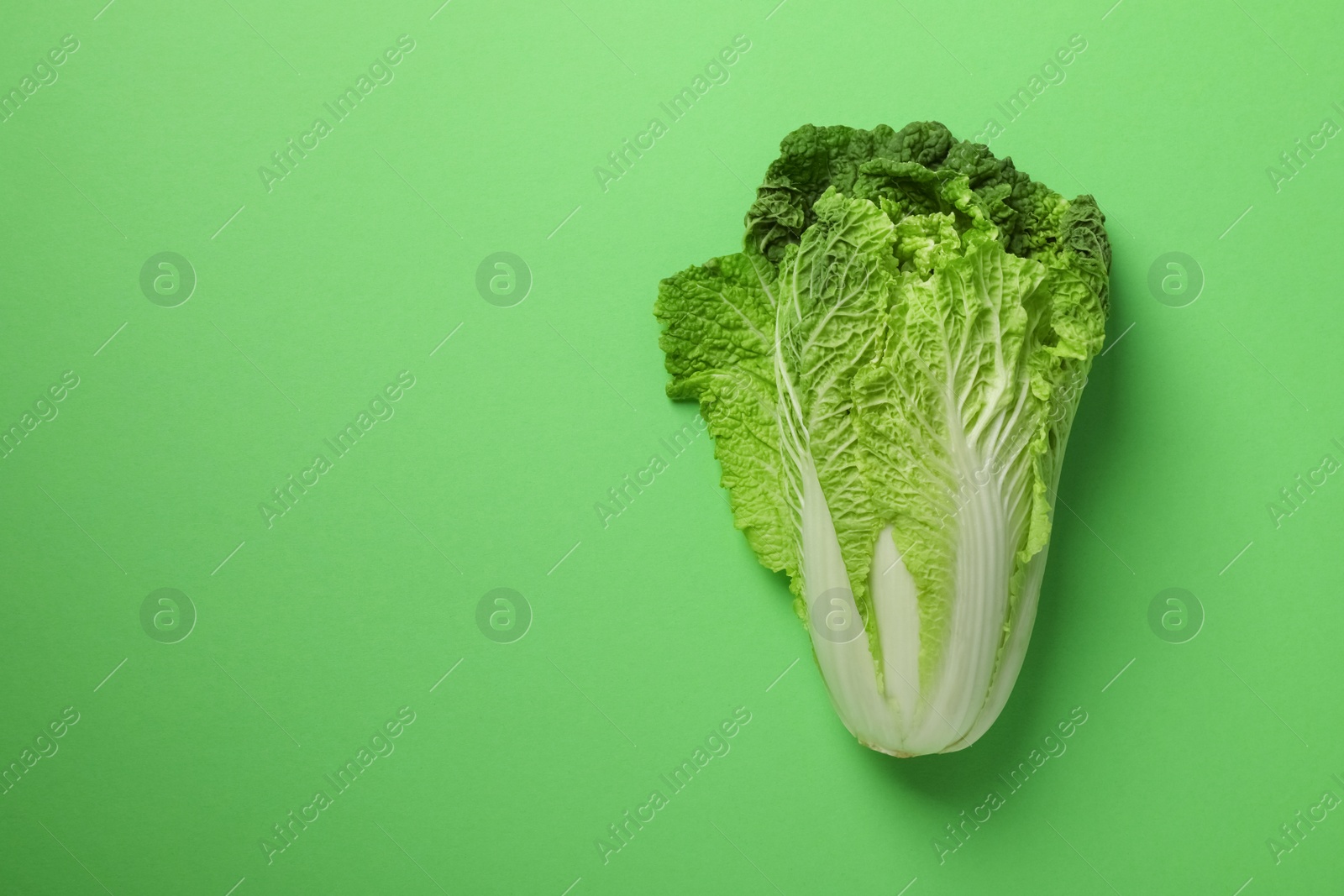 Photo of Fresh ripe Chinese cabbage on light green background, top view. Space for text
