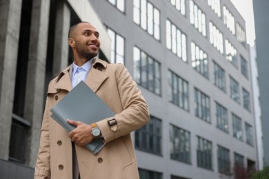 Happy man with folders outdoors, space for text. Lawyer, businessman, accountant or manager