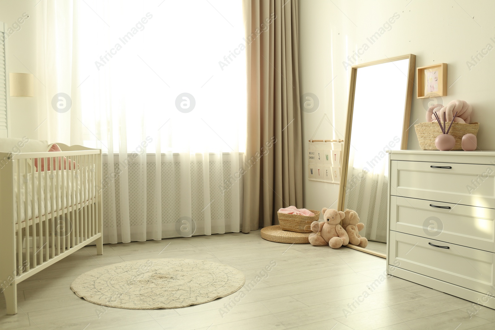 Photo of Beautiful nursery interior with white chest of drawers