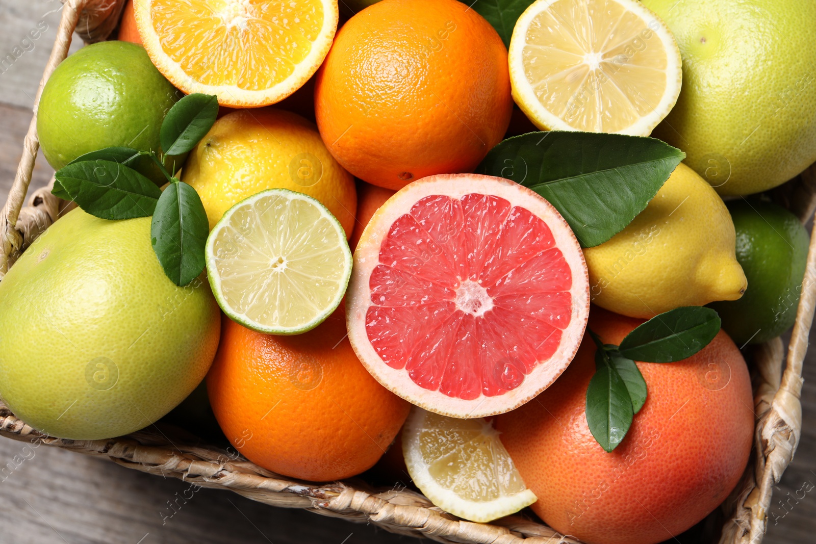 Photo of Different cut and whole citrus fruits on table, top view