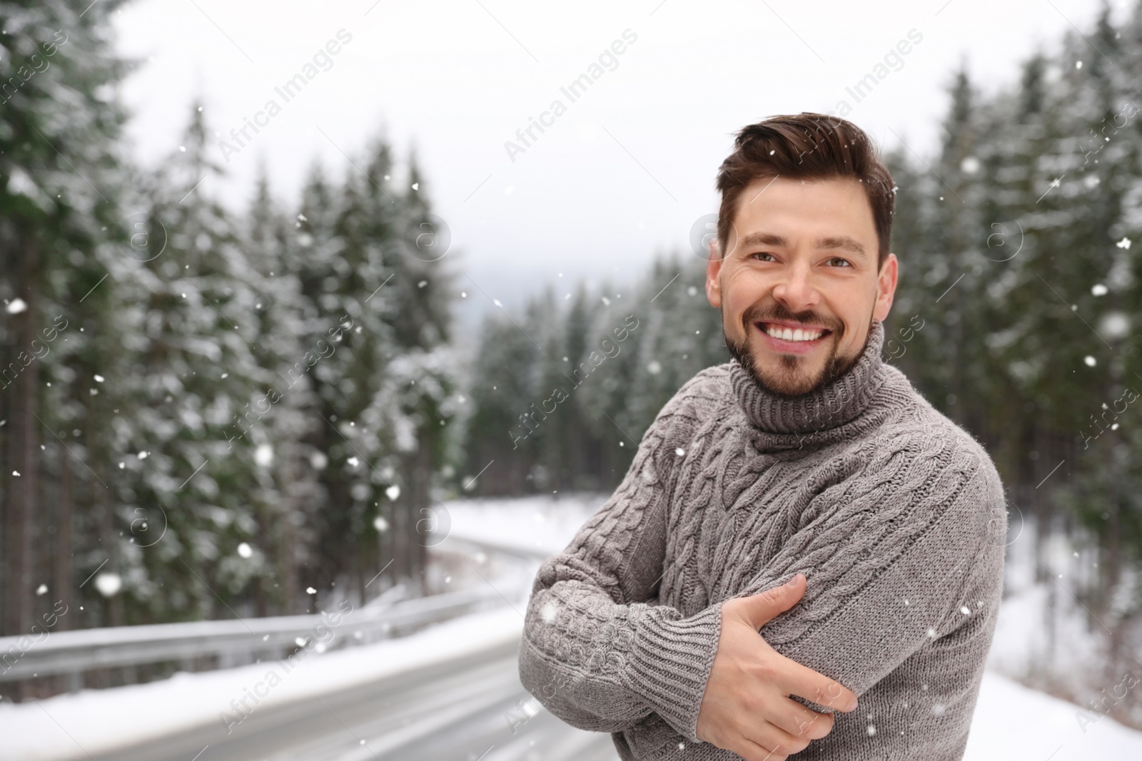 Photo of Man in warm sweater outdoors on snowy day, space for text. Winter vacation