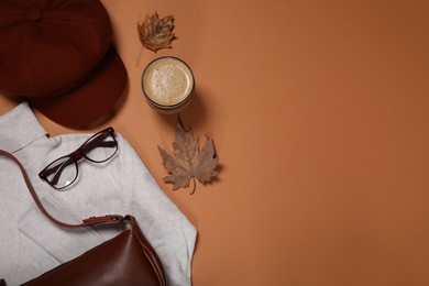 Photo of Flat lay composition with stylish hat and coffee on orange background, space for text
