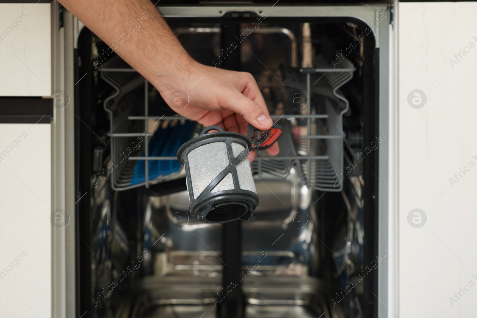 Photo of Repairman holding drain filter near dishwasher, closeup