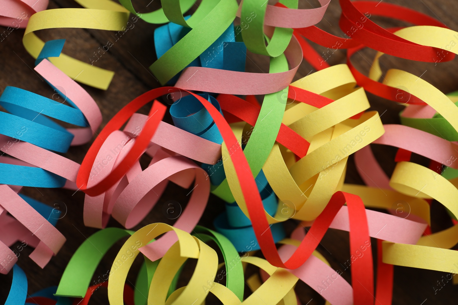 Photo of Colorful serpentine streamers on table, flat lay