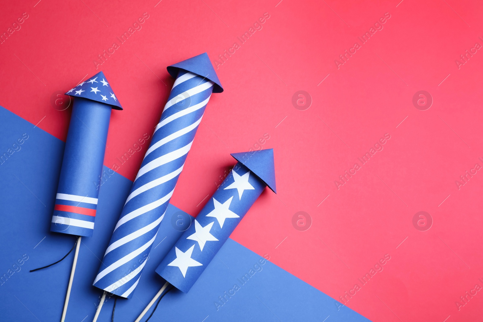 Photo of Firework rockets on color background, flat lay. Space for text