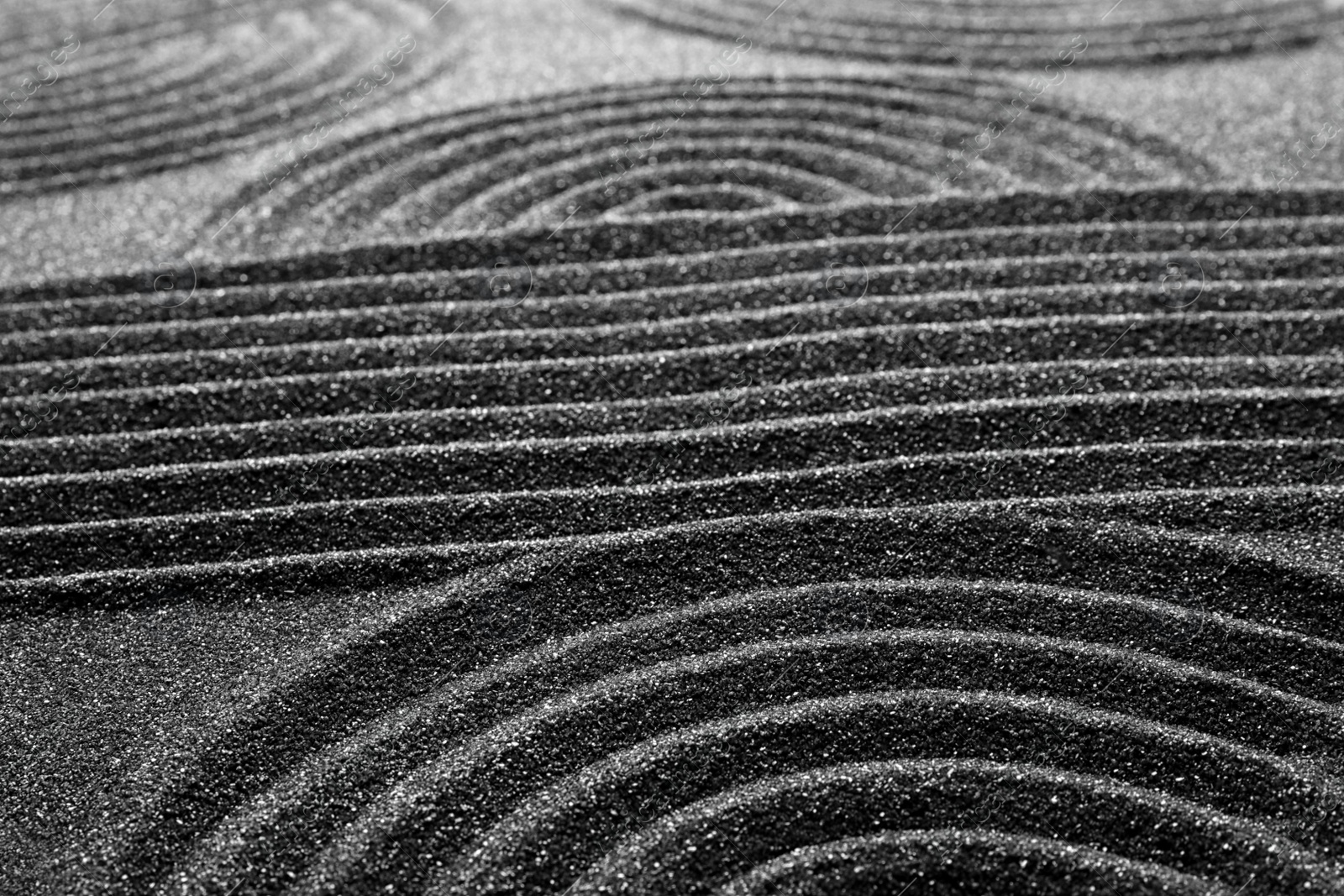 Photo of Pattern on decorative black sand, closeup. Zen and harmony