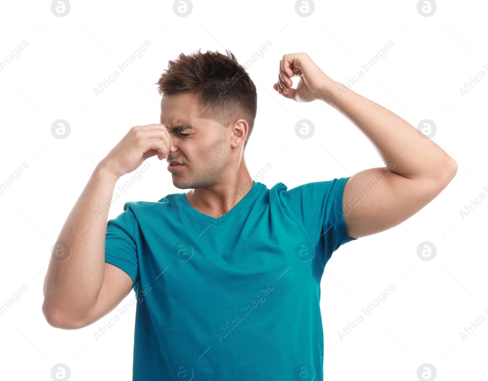 Photo of Young man with sweat stain on his clothes against white background. Using deodorant