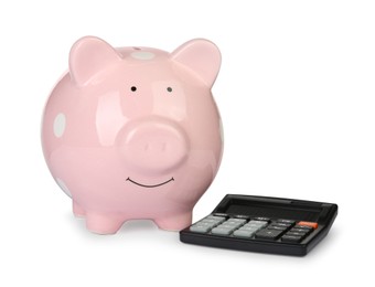 Photo of Piggy bank and calculator isolated on white