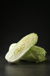 Whole and cut fresh Chinese cabbages on grey table