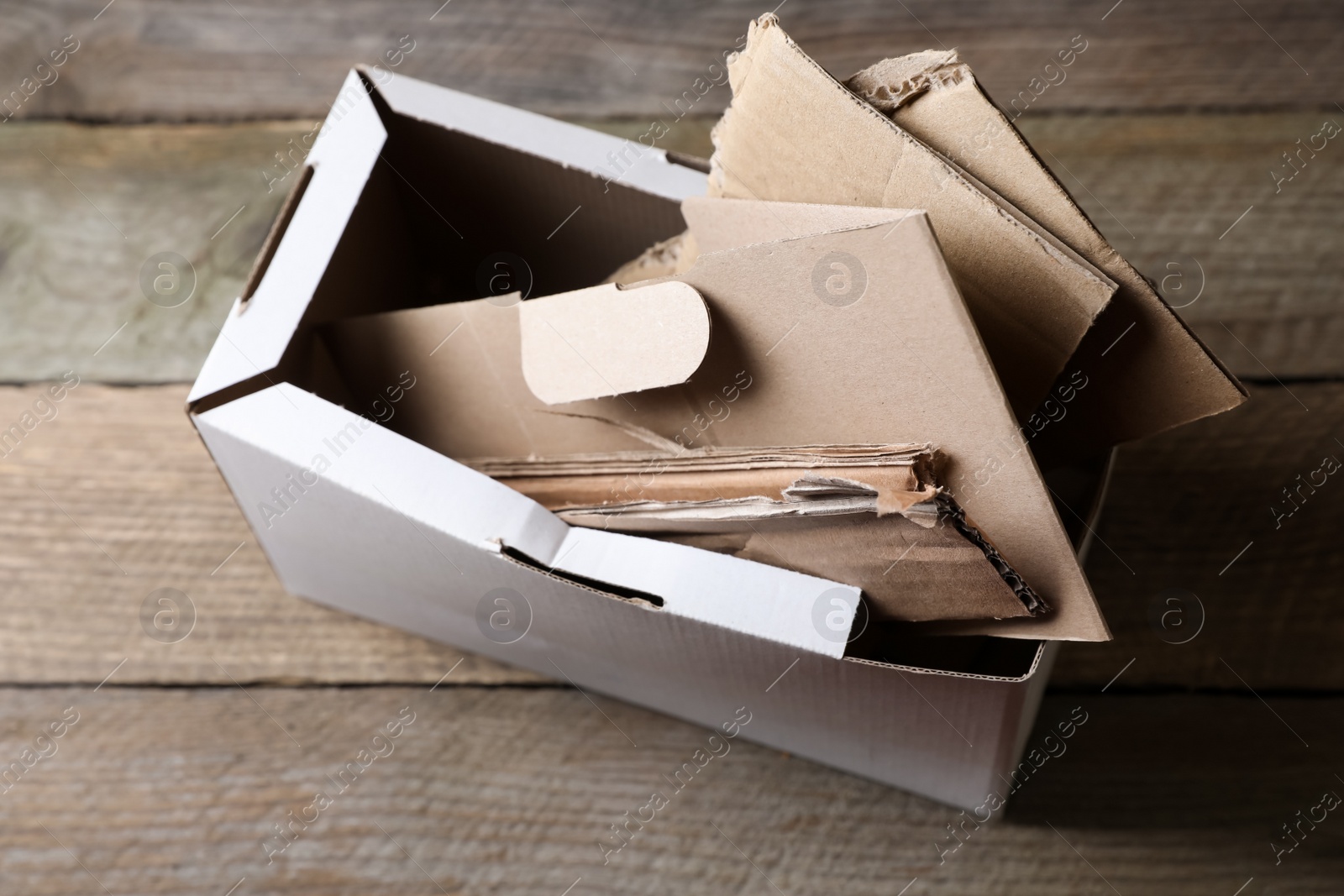 Photo of Box of waste paper on wooden table, view from above