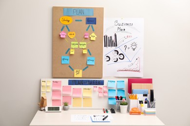 Photo of Business process planning and optimization. Workplace with colorful paper notes and other stationery on white wooden table