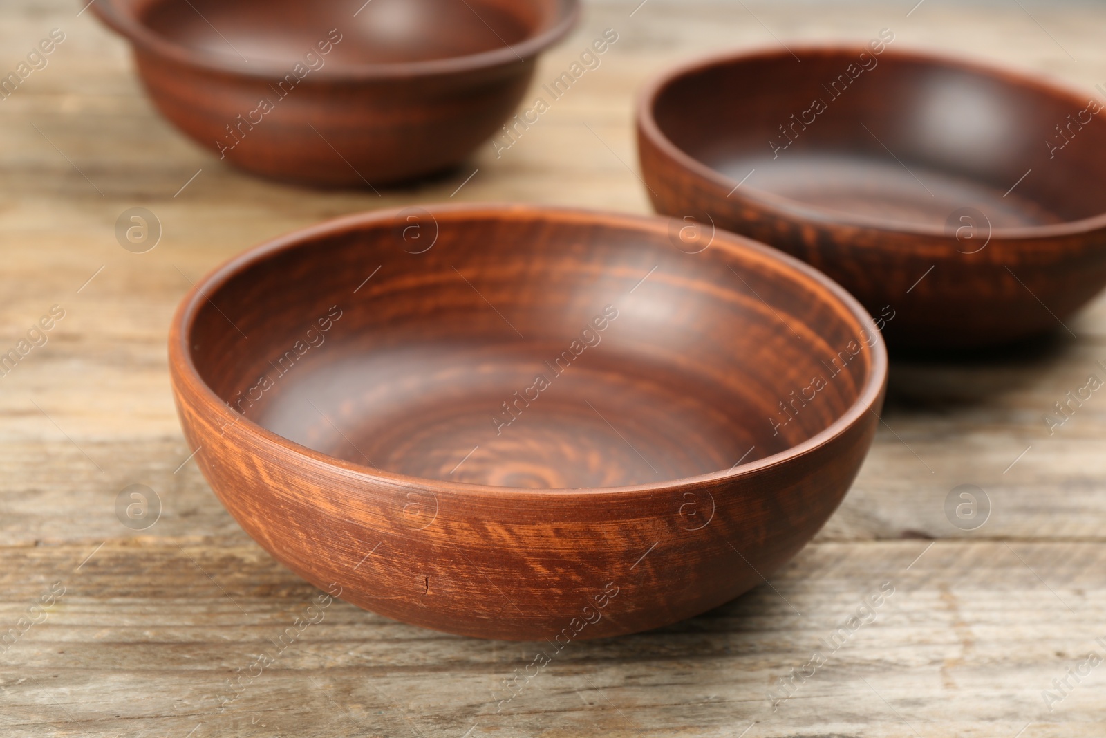 Photo of Stylish clay bowls on wooden table, closeup