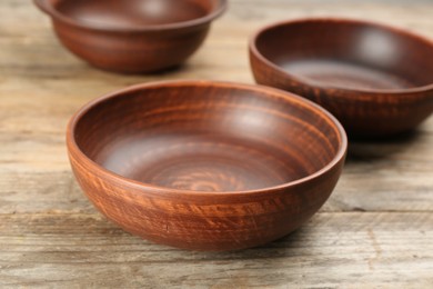 Stylish clay bowls on wooden table, closeup