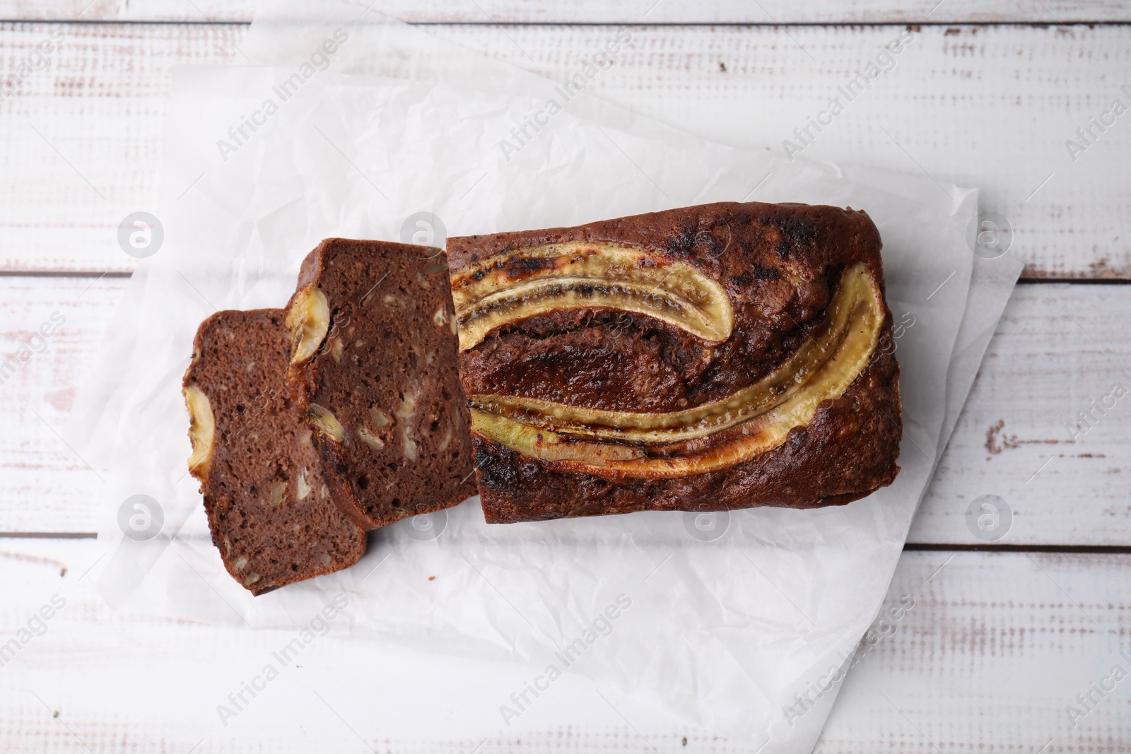 Photo of Delicious banana bread on white wooden table, top view
