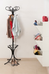 Photo of Shoe cabinet with footwear in room. Storage ideas