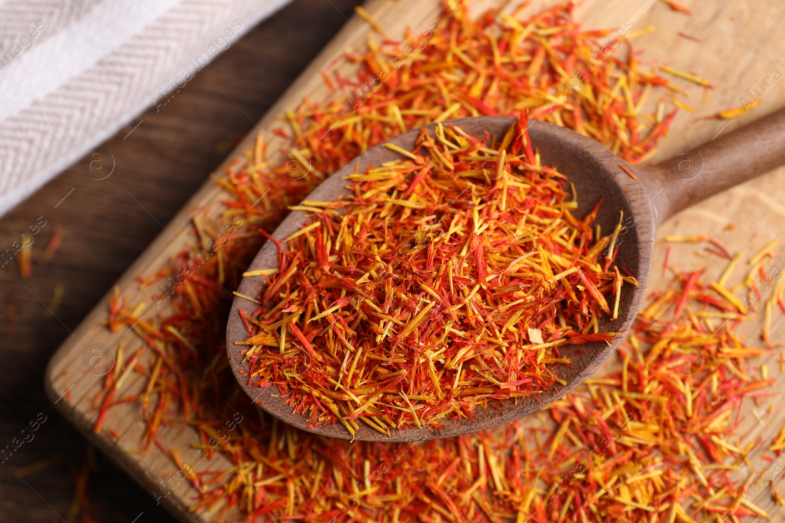 Photo of Aromatic saffron and spoon on wooden table, top view