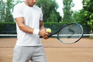 Photo of Sportsman preparing to serve tennis ball at court, closeup