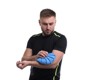 Young man with cold compress suffering from arm pain on white background