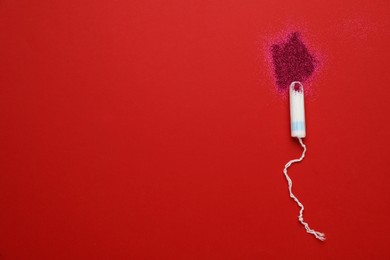 Photo of Tampon and pink glitter on color background, flat lay with space for text. Menstrual hygiene product