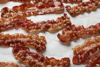 Photo of Slices of tasty fried bacon on white table