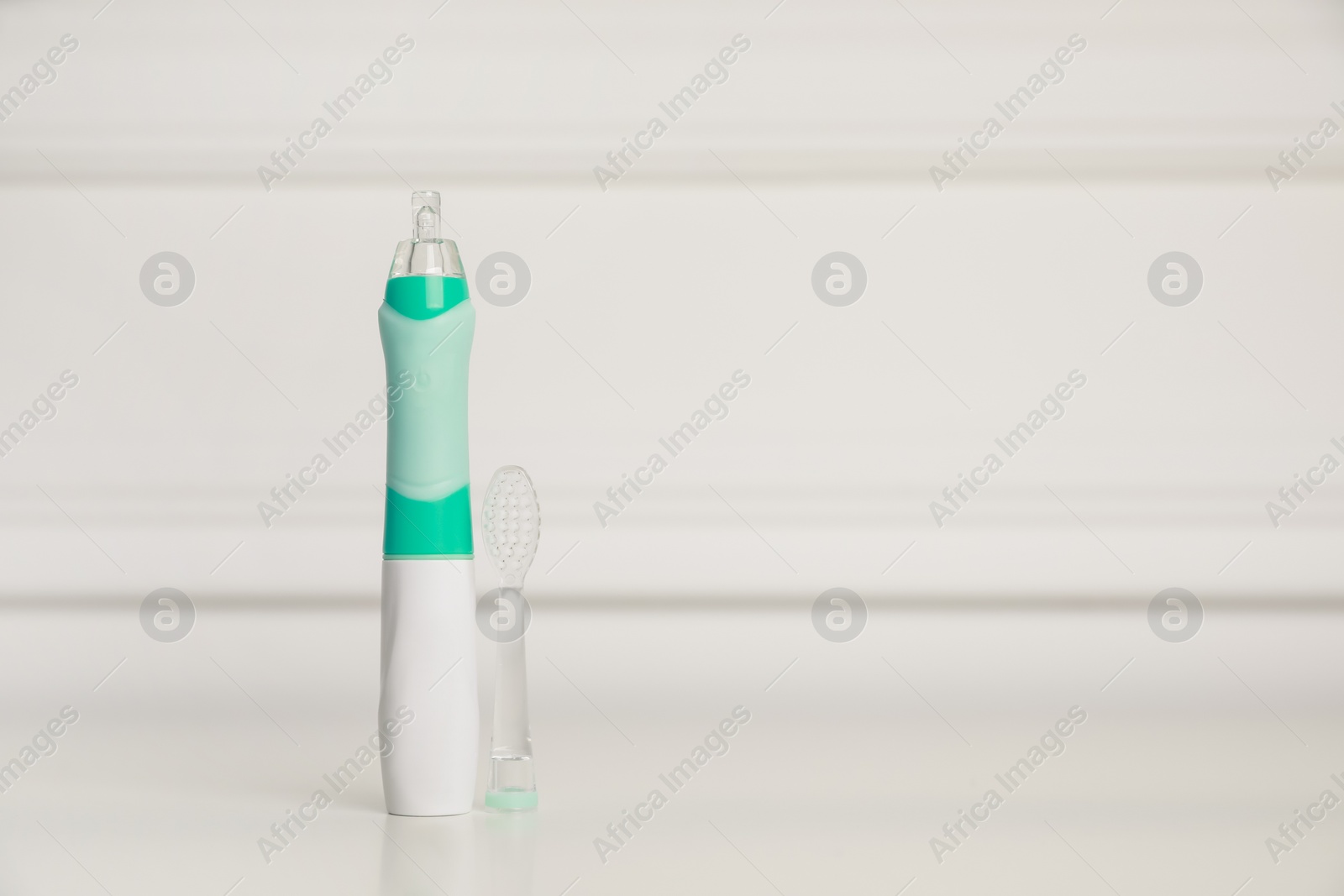Photo of Electric toothbrush on white background, space for text