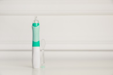 Photo of Electric toothbrush on white background, space for text