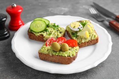 Crisp rye toasts with avocado on plate