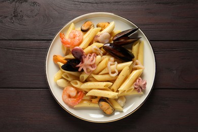 Photo of Delicious pasta with seafood served on wooden table, top view