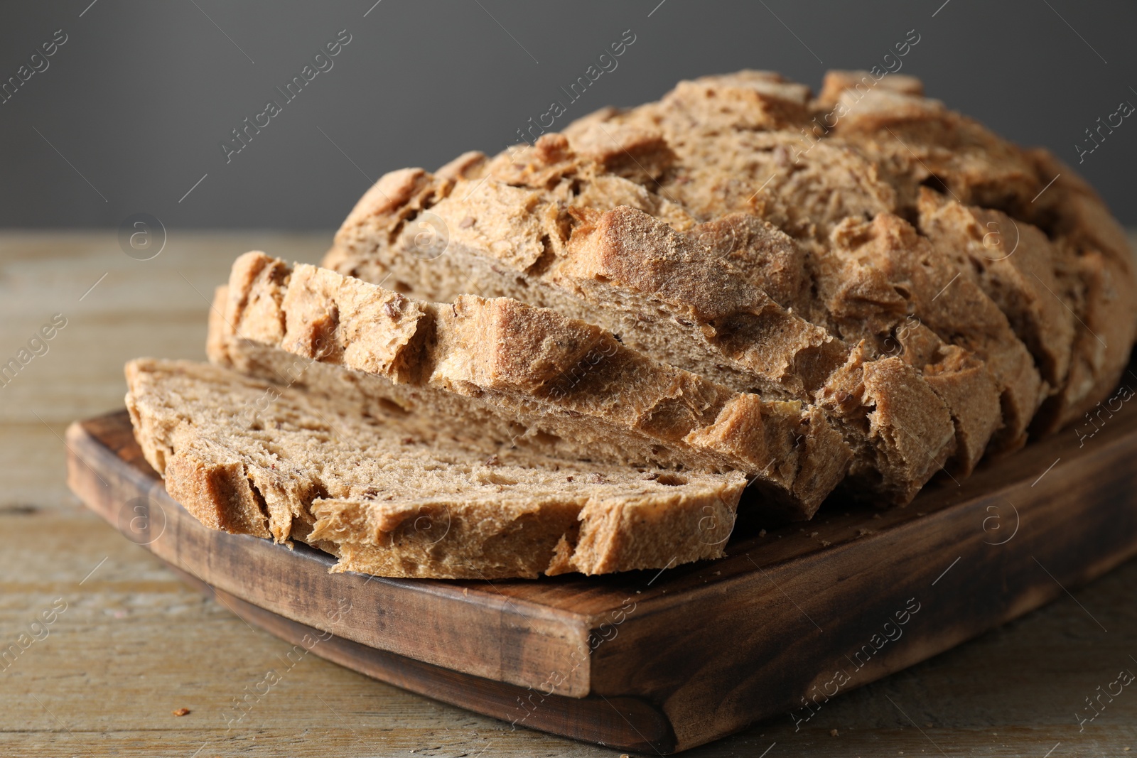 Photo of Freshly baked cut sourdough bread on wooden table, closeup