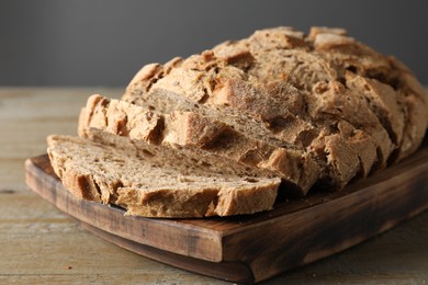 Photo of Freshly baked cut sourdough bread on wooden table, closeup