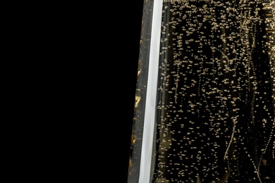 Photo of Glass of champagne on black background, closeup. Space for text