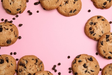 Photo of Delicious chocolate chip cookies on color background, flat lay. Space for text