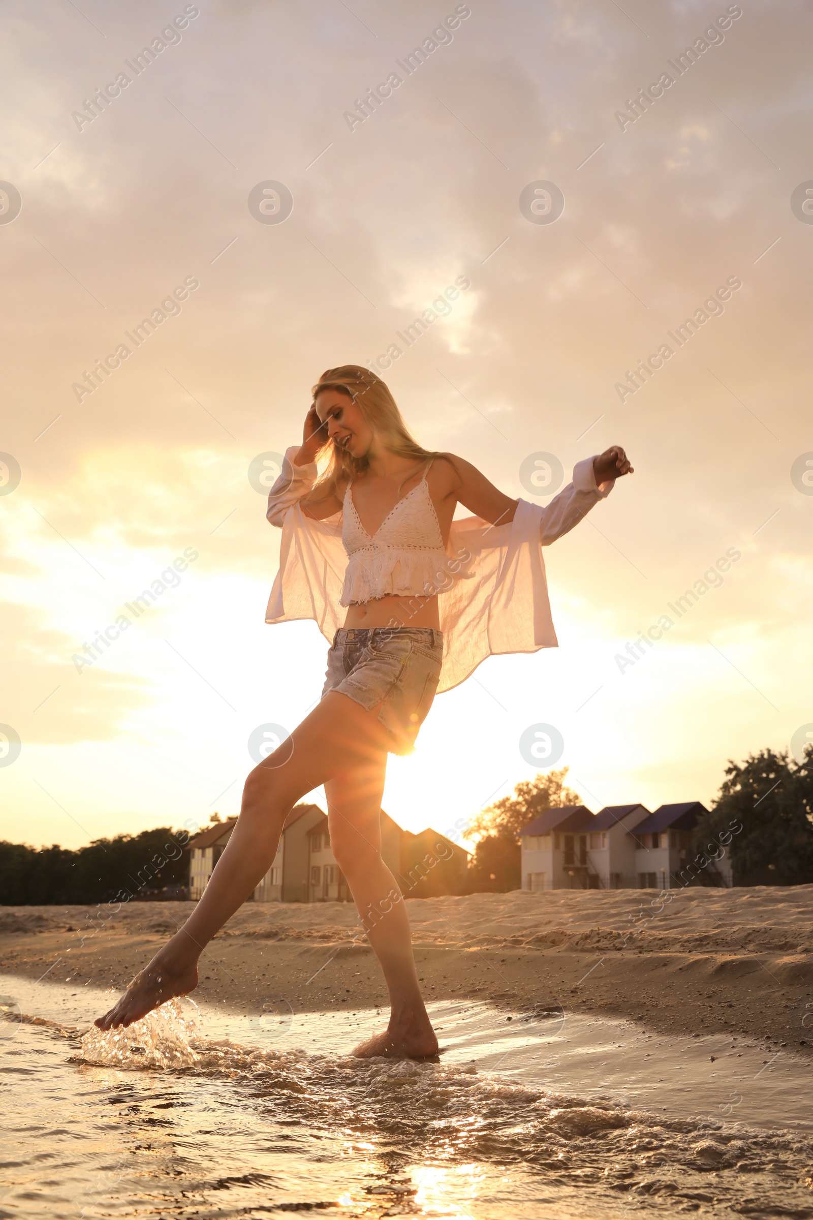 Photo of Beautiful young woman playing with water on sea beach