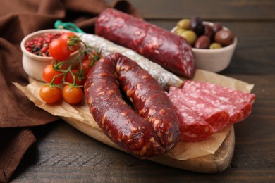 Different types of tasty sausages on wooden table, closeup