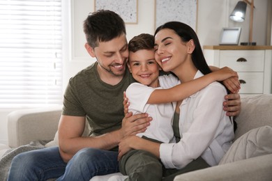 Photo of Happy family on sofa at home. Adoption concept