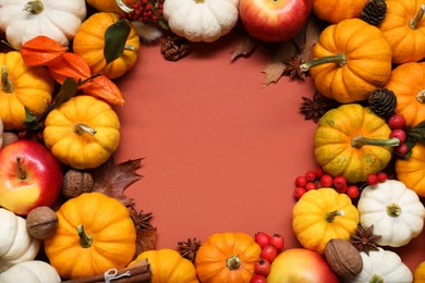 Photo of Thanksgiving day. Frame with pumpkins and apples on brown background, flat lay. Space for text