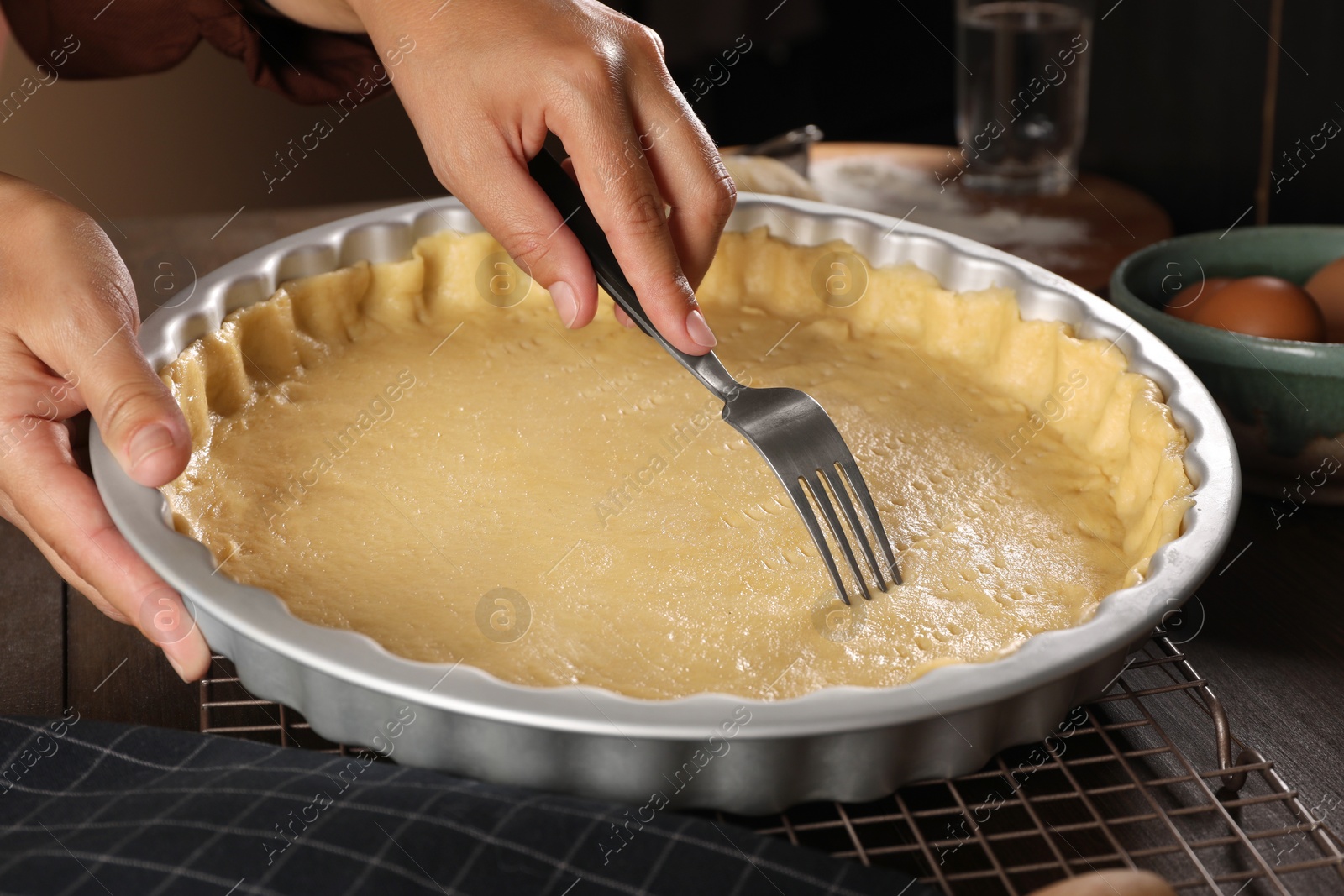 Photo of Woman making quiche at wooden table, closeup