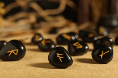 Photo of Many black rune stones on wooden table, closeup