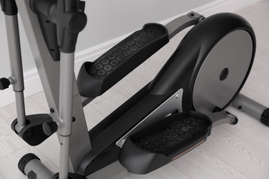 Photo of Modern elliptical machine cross trainer on floor indoors