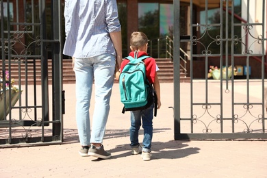 Photo of Young father taking his little child to school outdoors