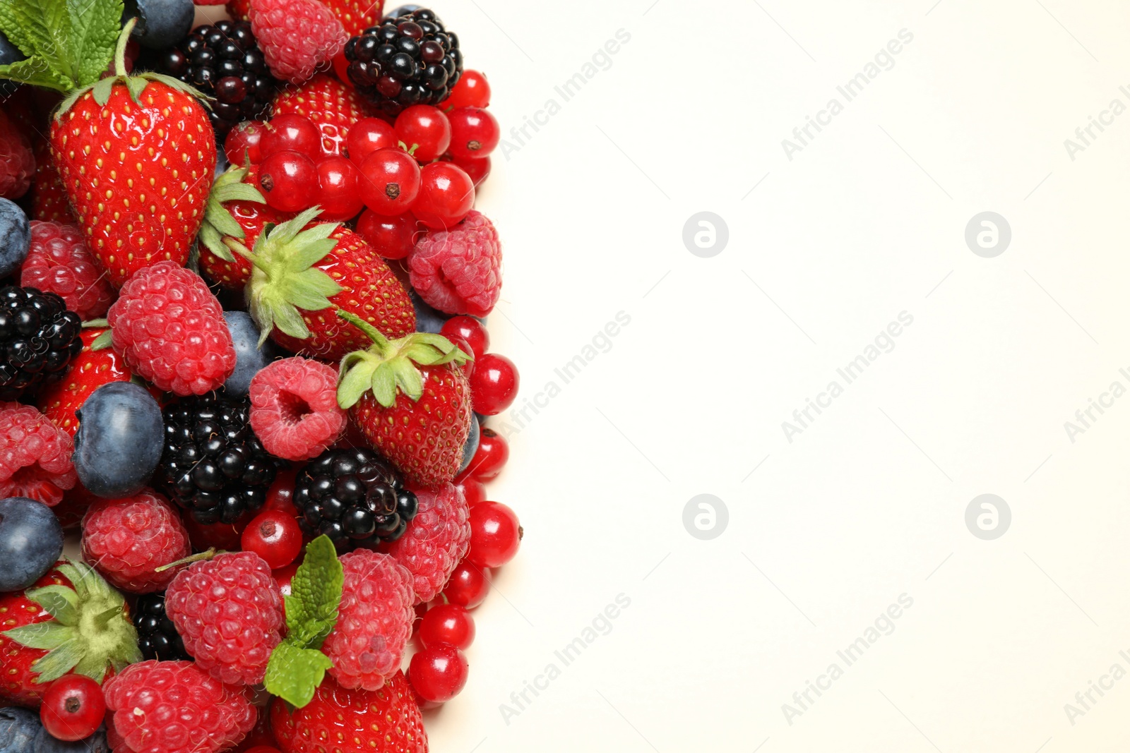 Photo of Mix of different fresh berries and mint on light background, flat lay. Space for text